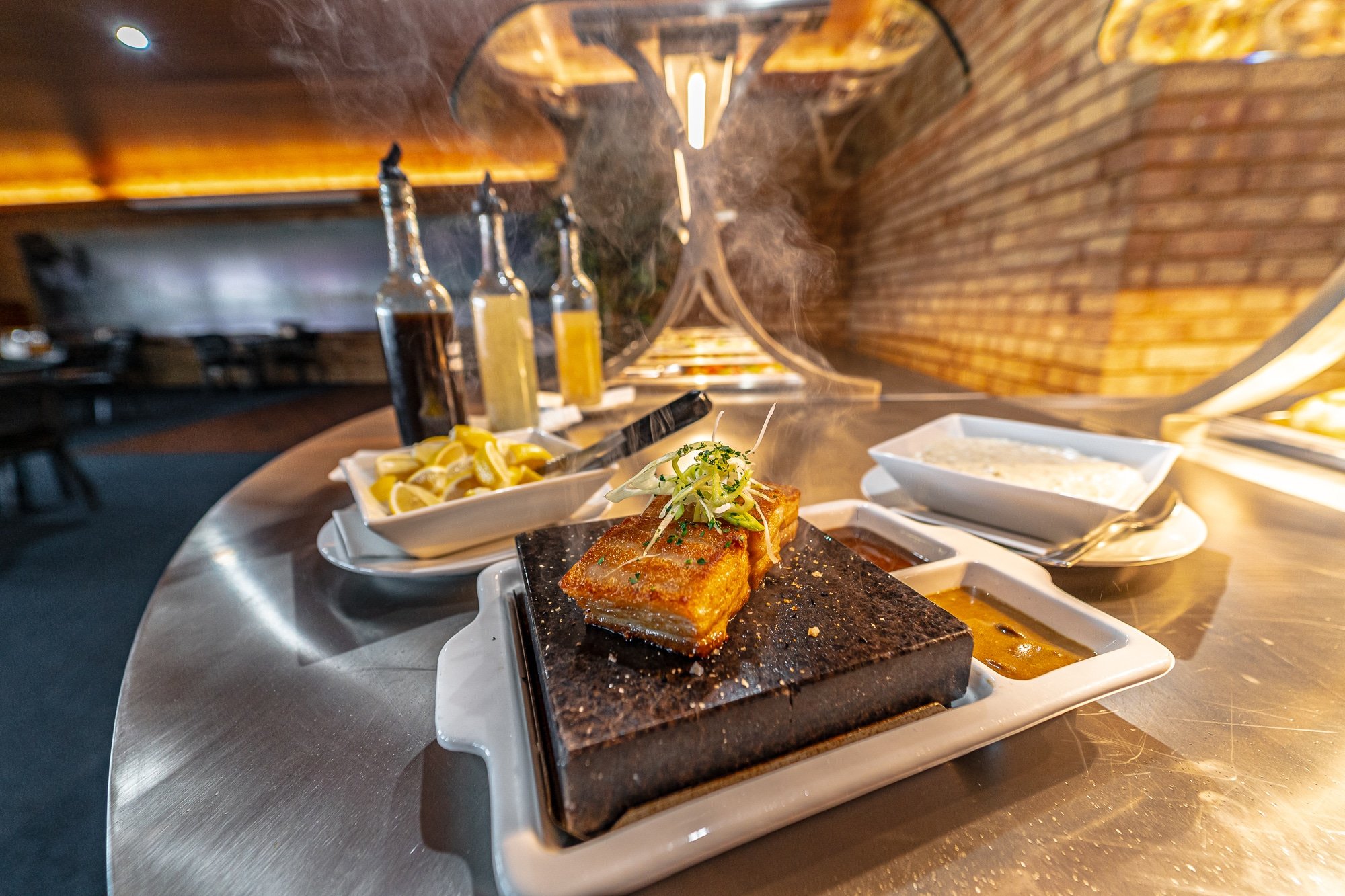 Pork belly sizzling on hot rock serving plate